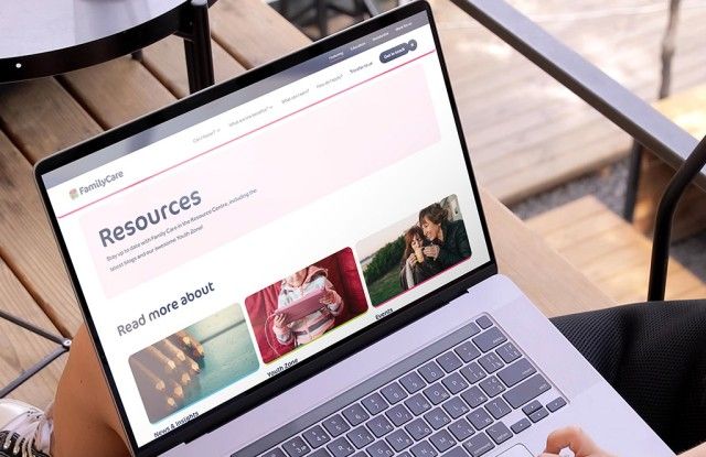 Woman holding a laptop and browsing the About us page on the Family Care website
